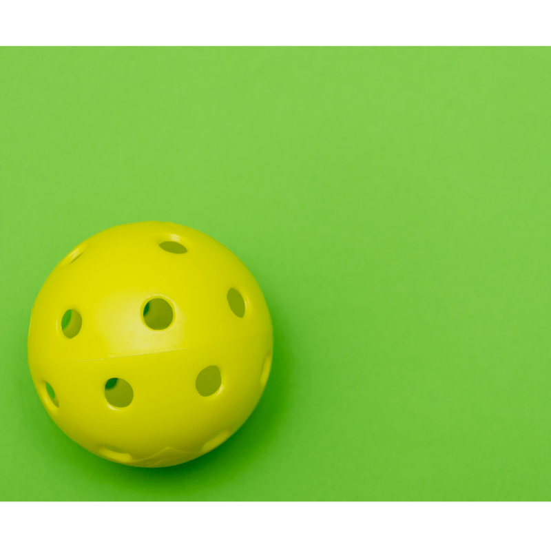 yellow pickleball on green background